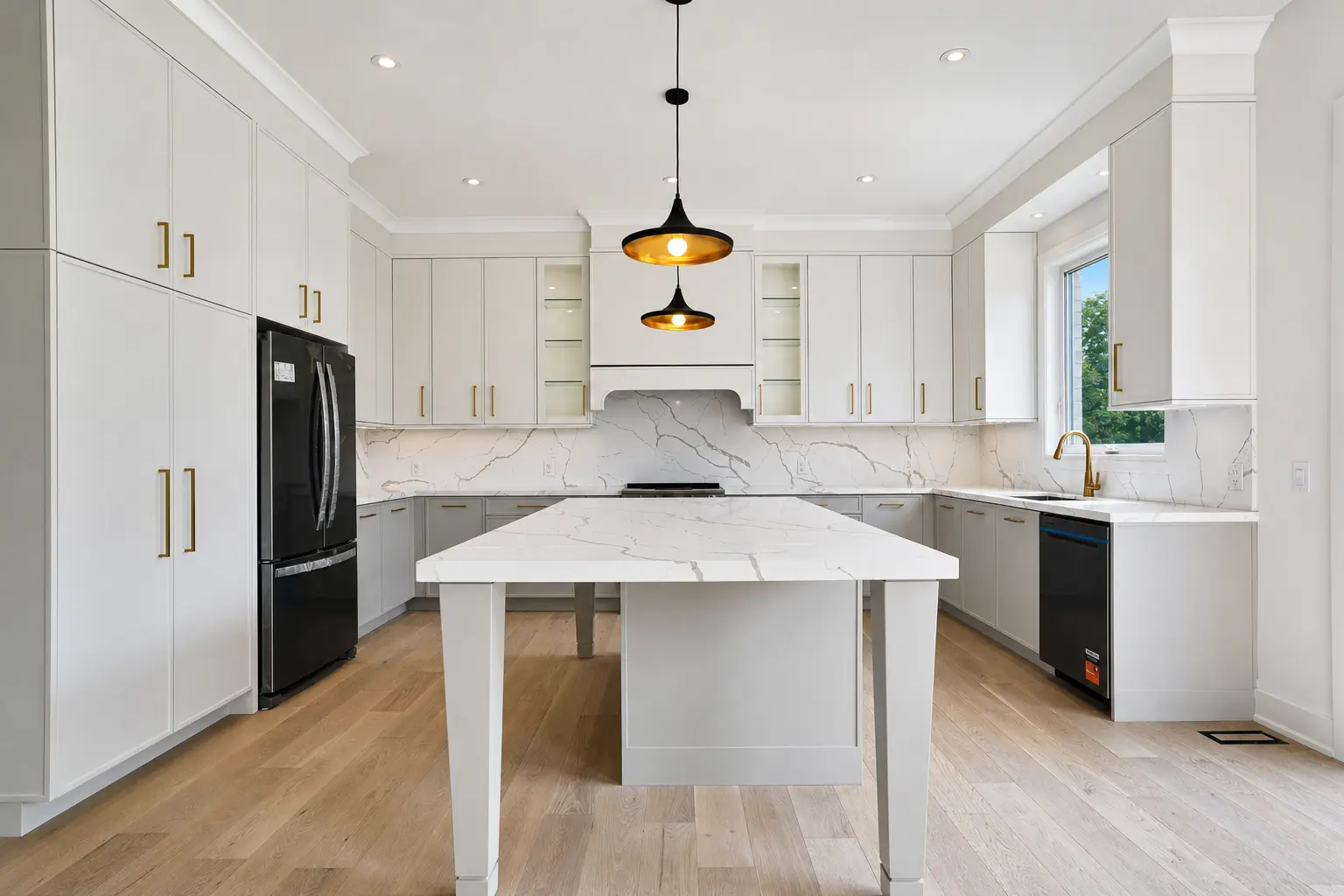 Kitchen with marble backsplash, waterfall island and brass hardware