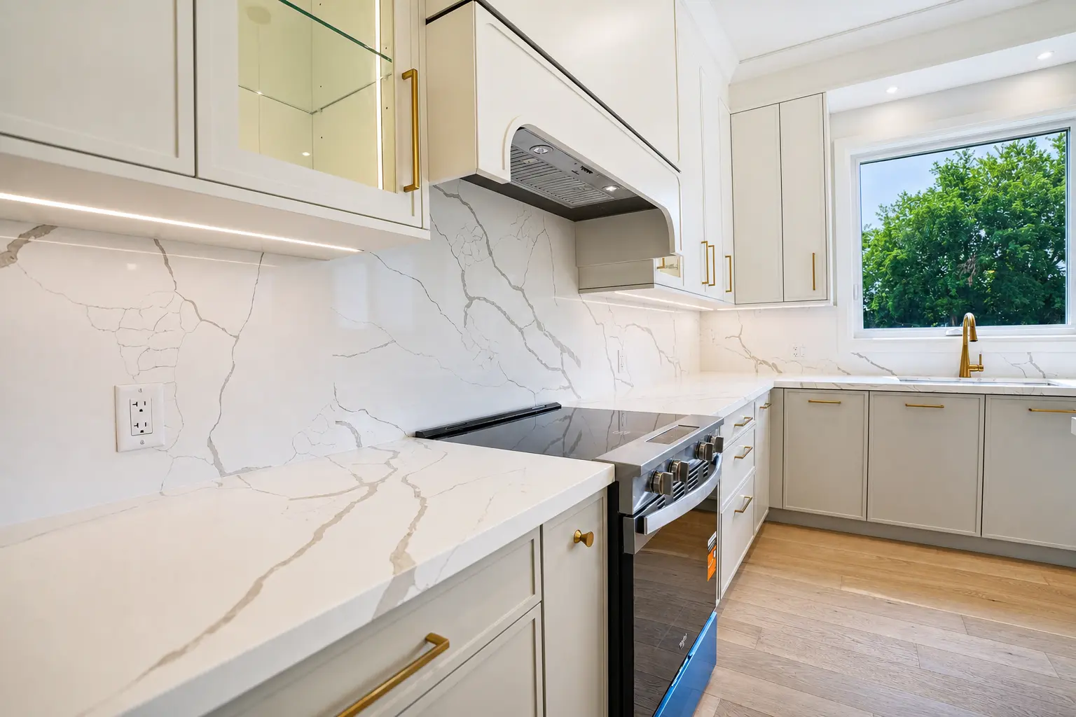Kitchen counters in marble-look quartz with brass fixtures