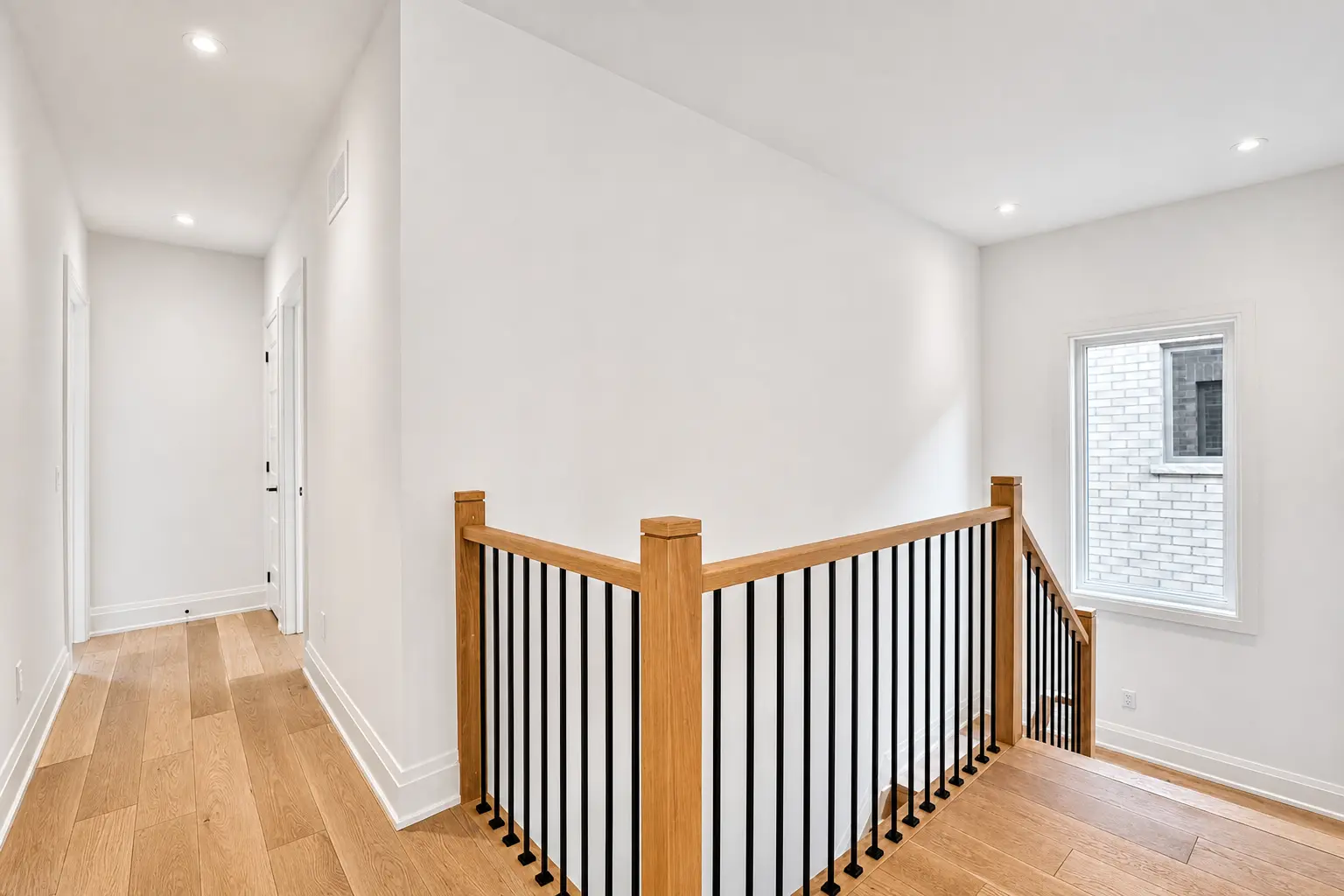 Upper landing with oak railing, iron spindles and bedroom hallway