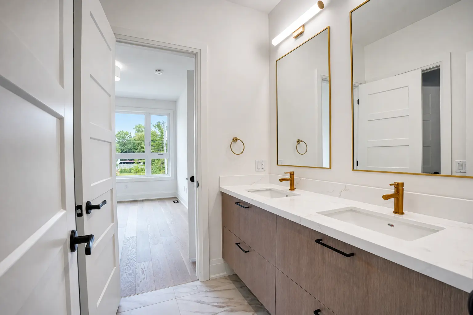 Shared bath with double vanity, brass faucets and framed mirrors
