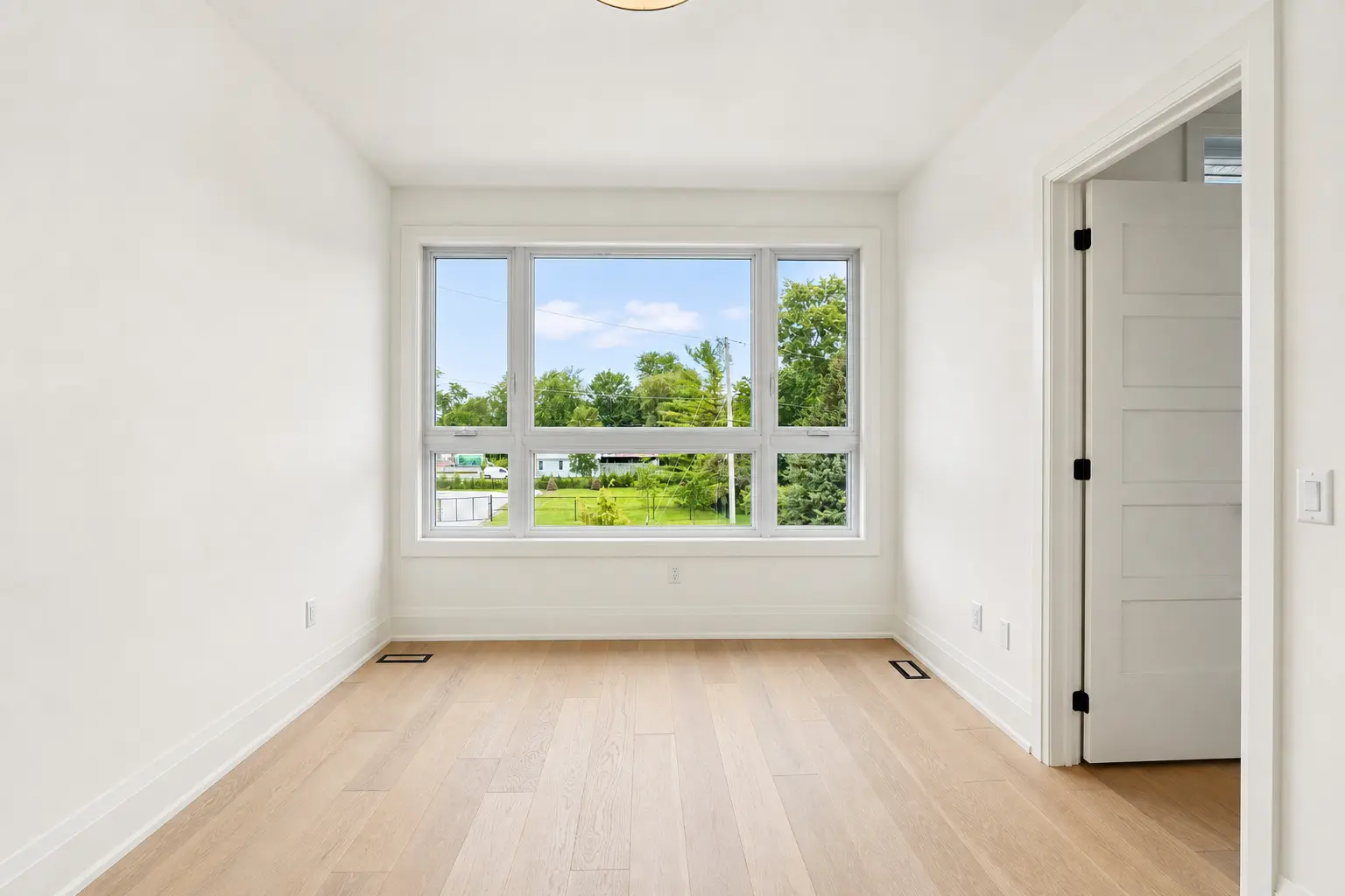 Bedroom with wide picture window overlooking the rear garden