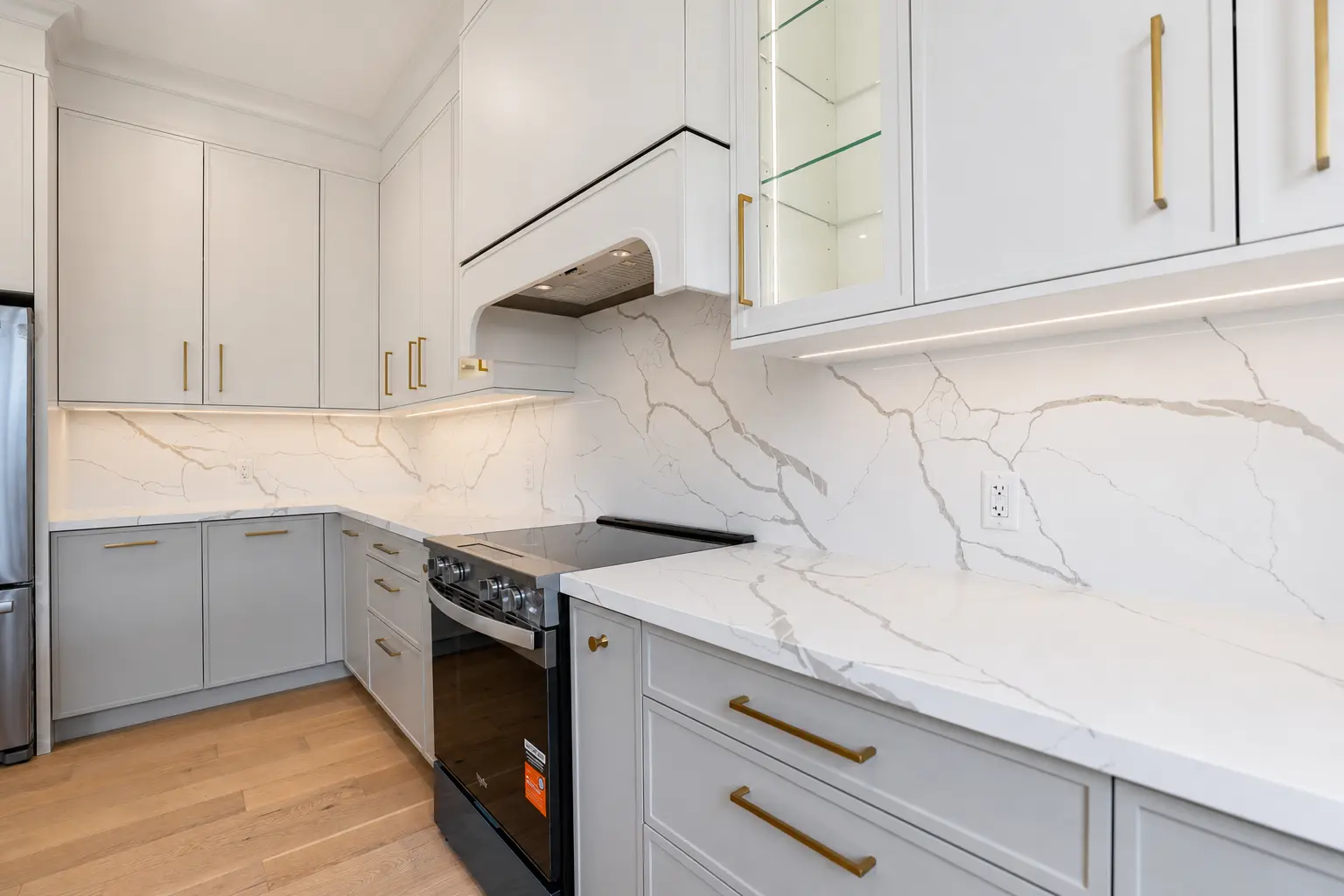 Kitchen range wall with full-height marble backsplash and custom hood
