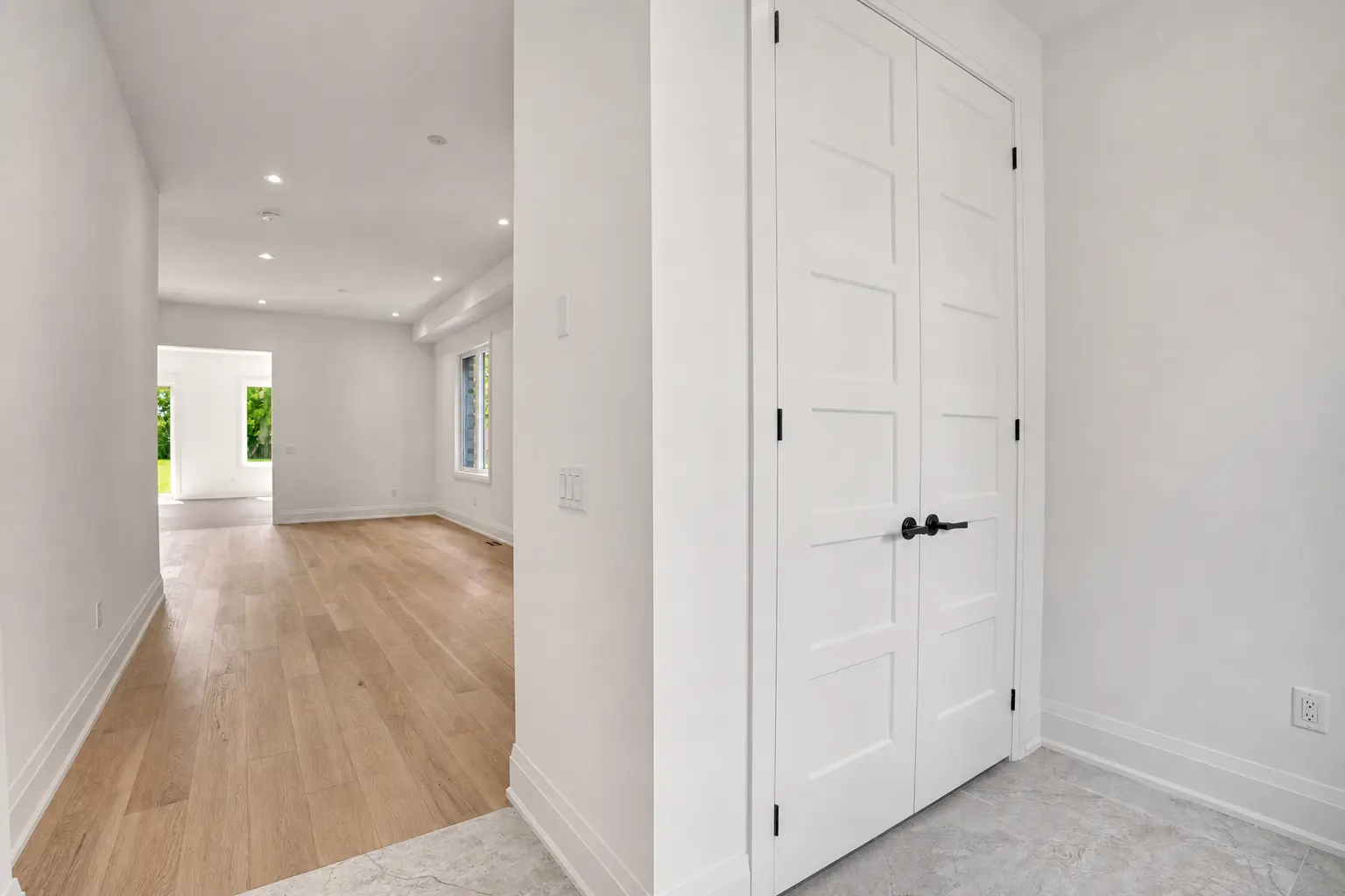 Entry hall with double closet doors looking through to the living space
