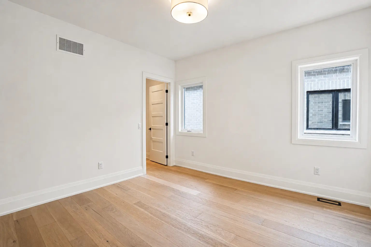 Bedroom with closet doorway and windows onto the side yard