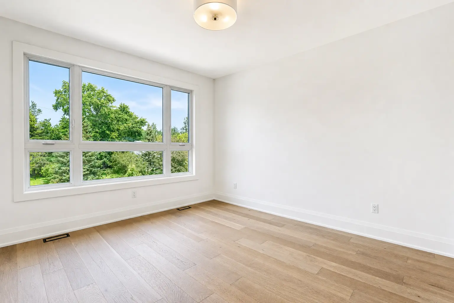 Corner bedroom with treetop views and oak floors
